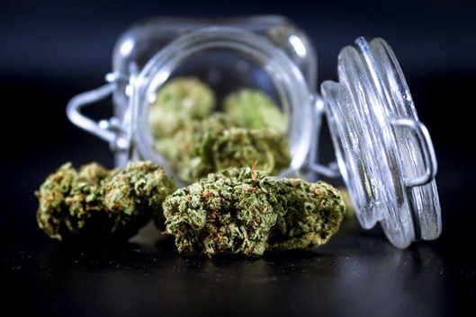 Cannabis flower in a glass jar in an adult-only recovery setting