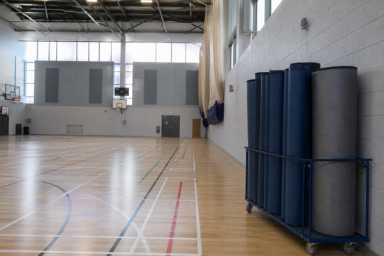 Spacious indoor gym with basketball hoops and exercise mats
